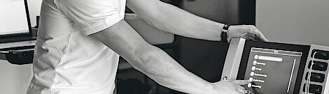 Ein Medizintechniker tippt auf das VIO3-Touchdisplay, um eine Option auszuwählen.