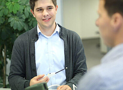 Im Rahmen der Berufsorientierung unterhält sich ein Auszubildener mit Fachpersonal.